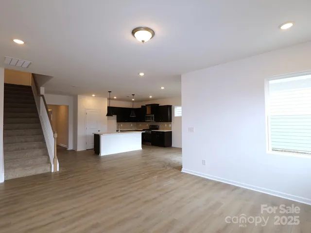 an open kitchen with a refrigerator a fireplace and a flat screen tv