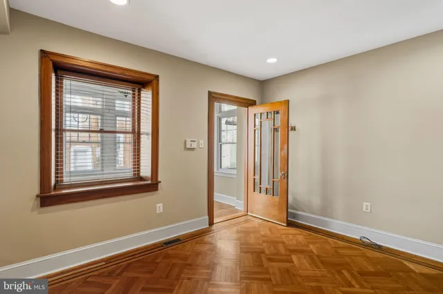 a view of an empty room with window and closet area