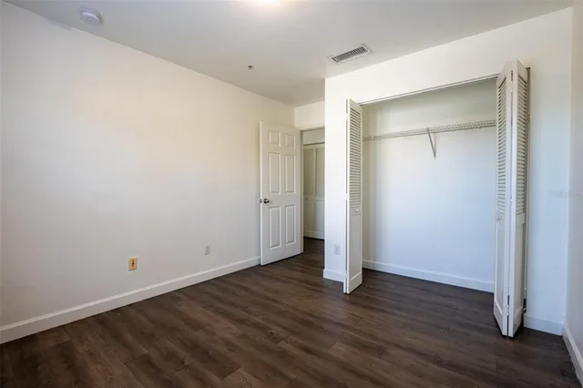 an empty room with wooden floor and closet