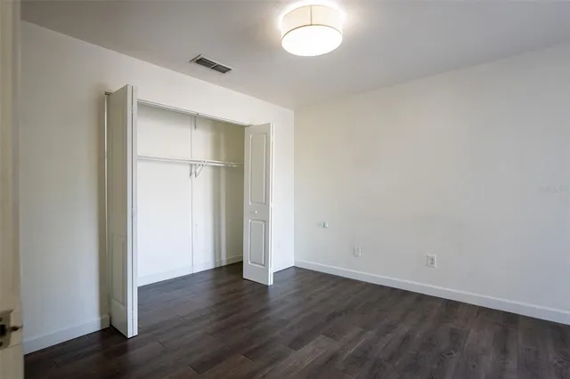 an empty room with wooden floor and window