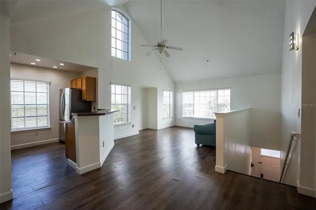 wooden floor in kitchen and an empty room with wooden floor and a kitchen
