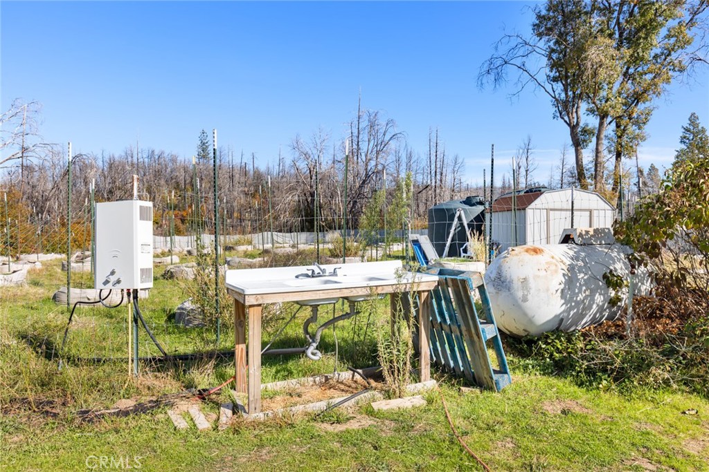 1809 Bald Rock Road Berry Creek, CA 95916 - Photo 10 of 37 a view of a patio with table and chairs a barbeque and potted plants and covered with tall trees