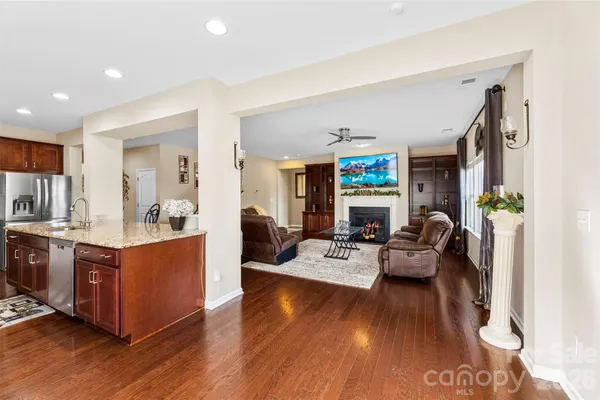 a large living room with stainless steel appliances furniture and a wooden floor