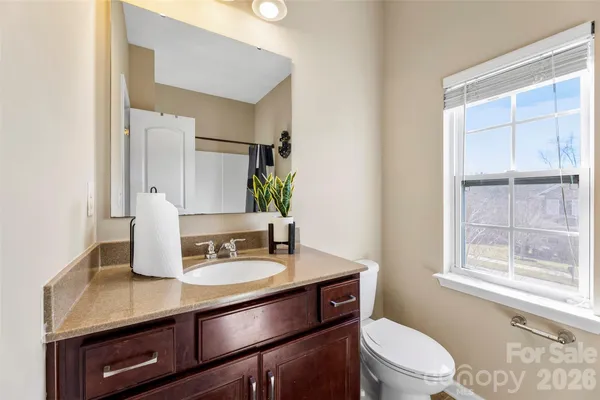 a bathroom with a sink a toilet a mirror and window