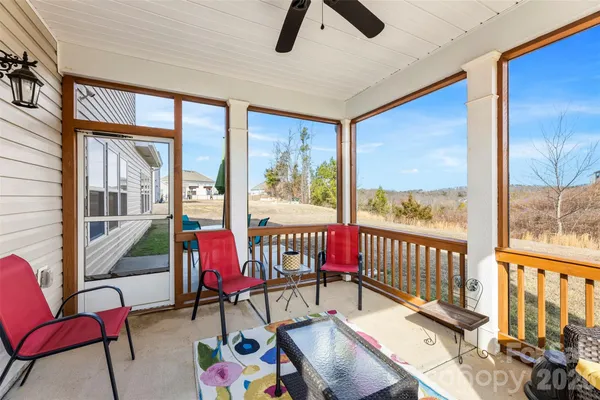 a living room with furniture and floor to ceiling windows