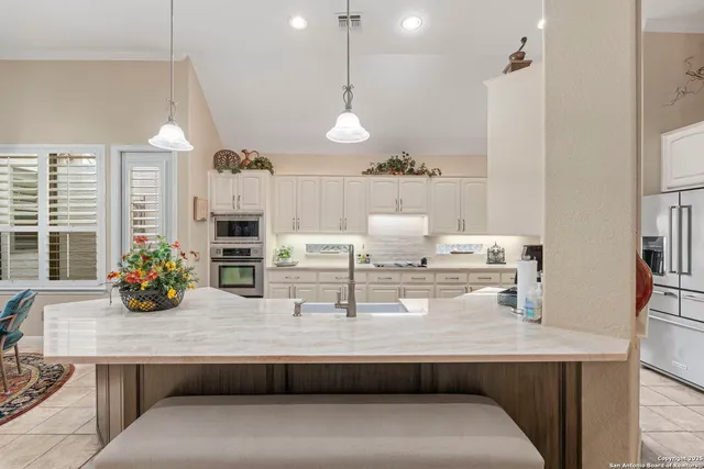 a room with counter space cabinets and chandelier
