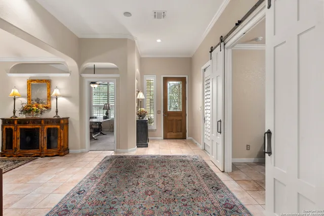 a view of a hallway with wooden floor and living room