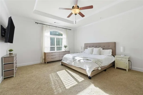 a bedroom with a bed a window and a flat screen television