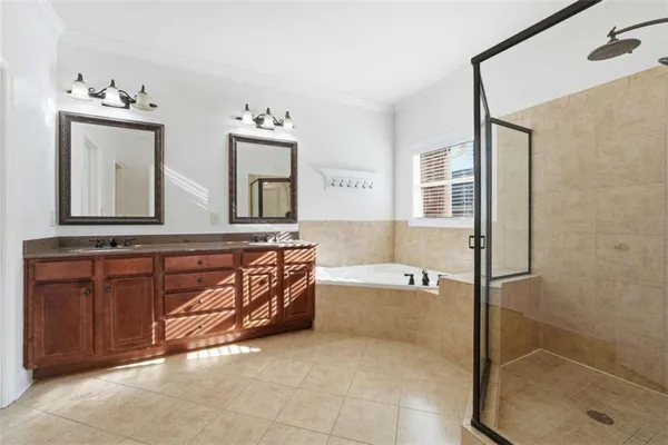 a bathroom with a tub a double vanity sink and a mirror