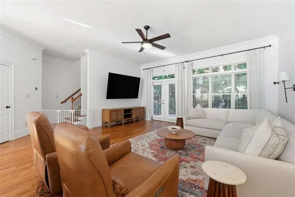 a living room with furniture a flat screen tv and a large window