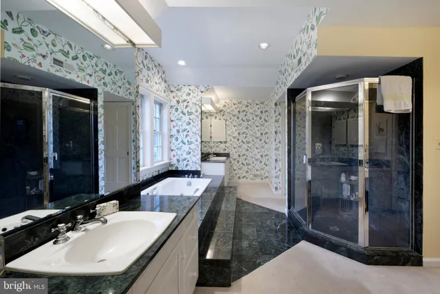 a bathroom with a sink a toilet a mirror and shower