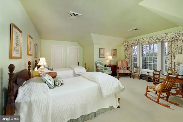 a large white kitchen with granite countertop a stove a sink a refrigerator and white cabinets with wooden floor