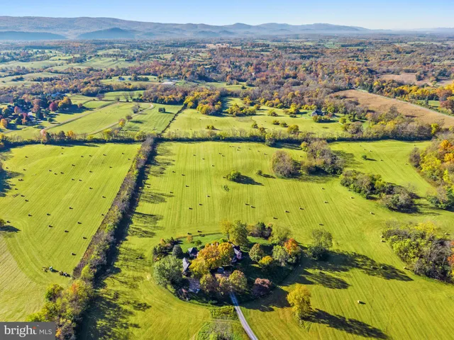 a front view of multi story residential apartment building with outdoor seating and green space
