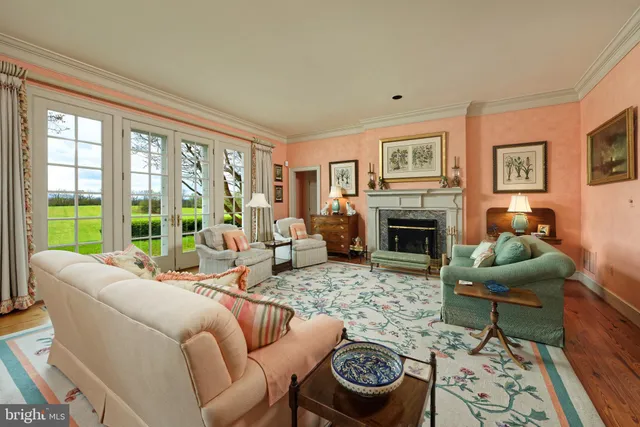 a living room with furniture a bookshelf and a window