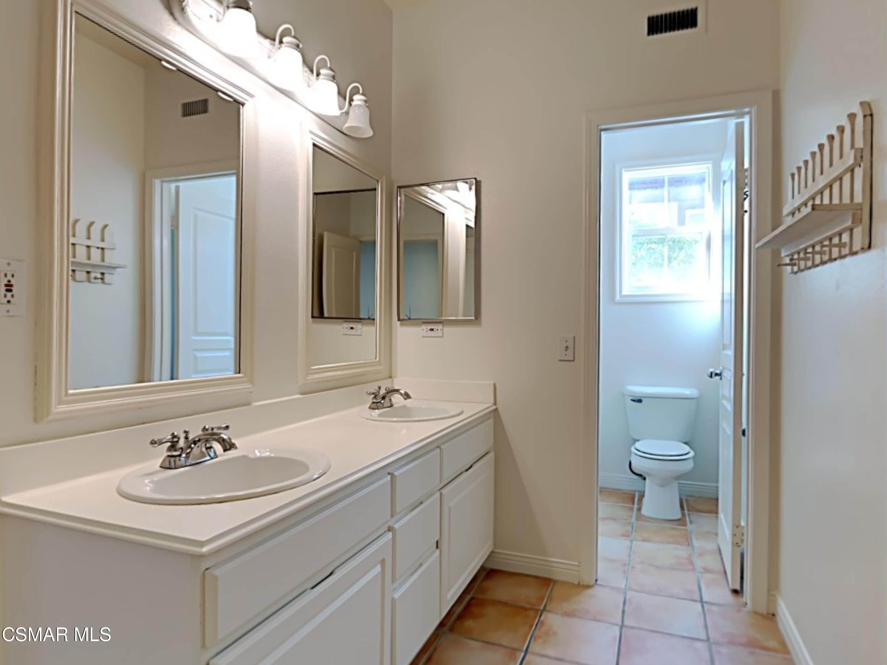 115 Parkside Drive Simi Valley, CA 93065 - Photo 18 of 27 a bathroom with a sink a toilet and a mirror