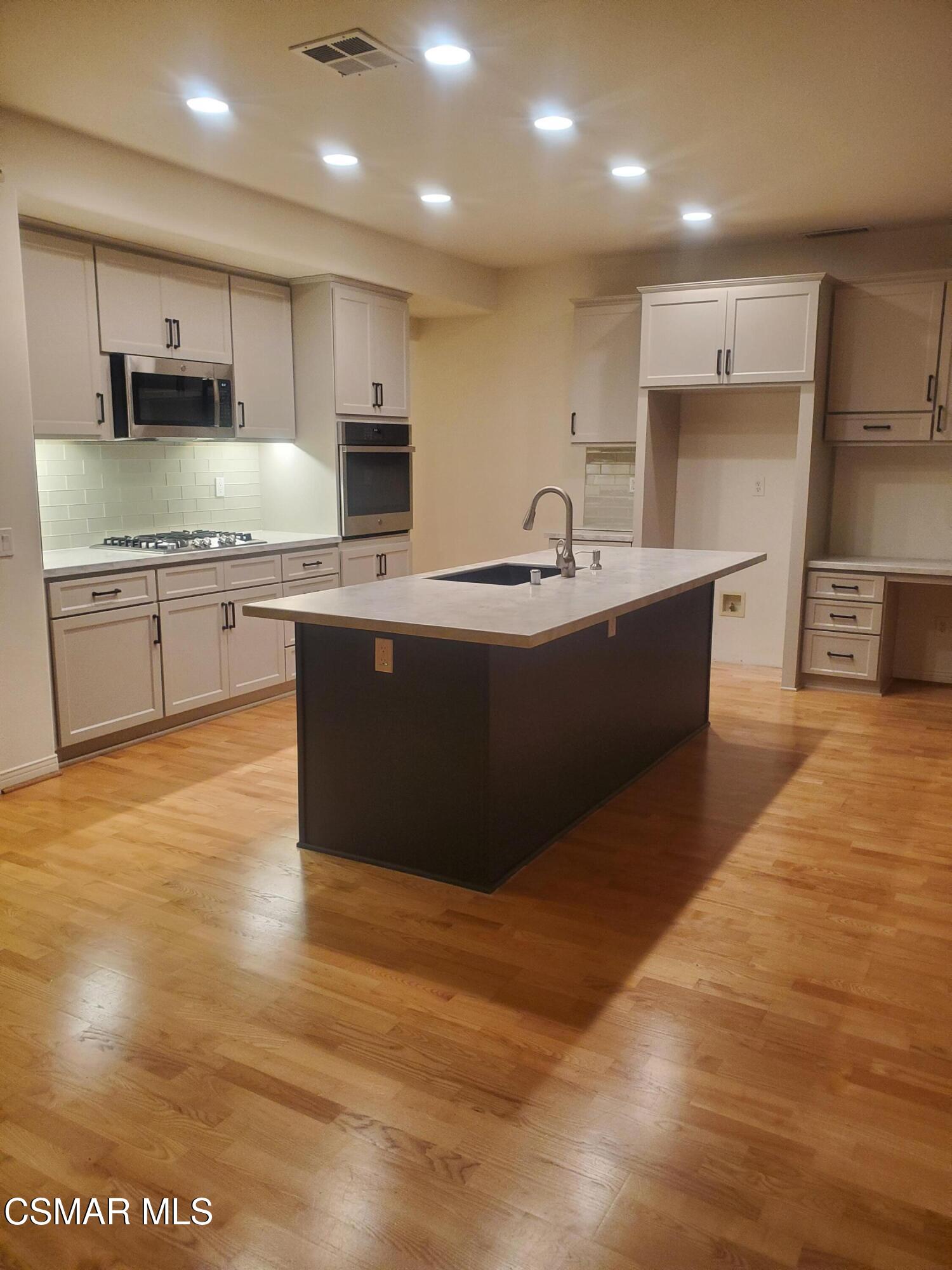 115 Parkside Drive Simi Valley, CA 93065 - Photo 5 of 27 a large kitchen with stainless steel appliances a large counter top a stove a sink and a refrigerator