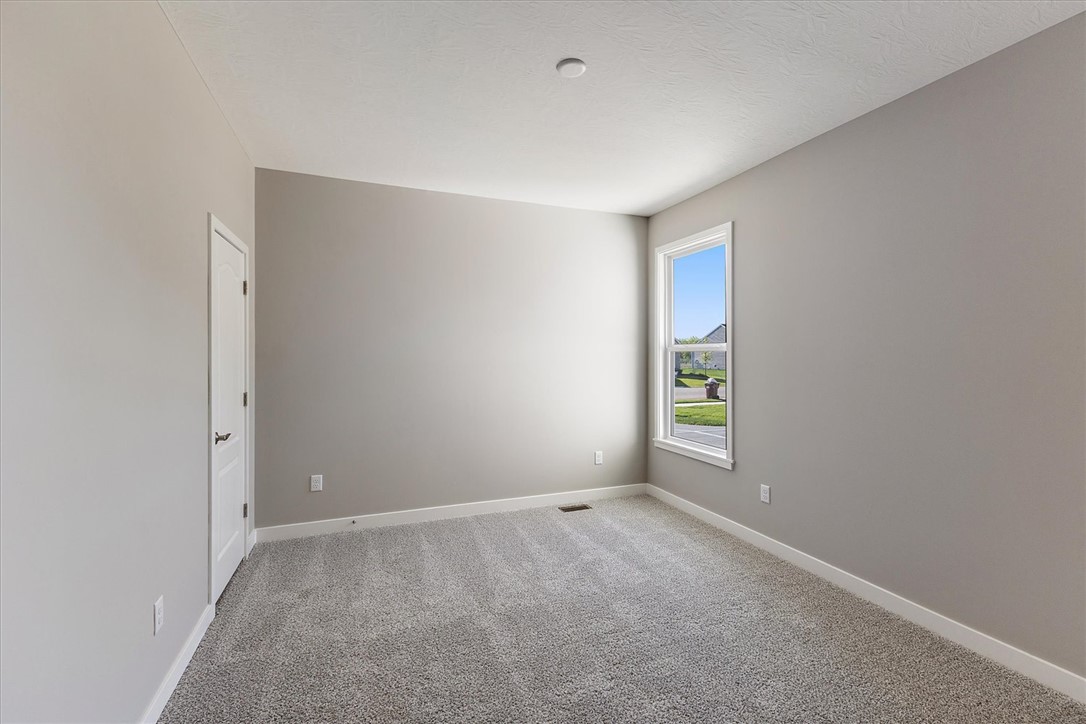 407 South Landon Lane Springfield, OH 45502 - Photo 17 of 30 A well-proportioned bedroom with soft gray walls and plush carpet offers serene comfort.