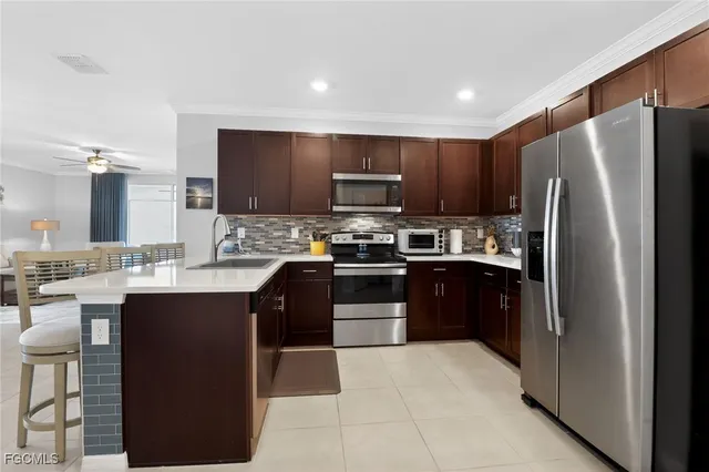 a kitchen with stainless steel appliances granite countertop a refrigerator stove and kitchen island