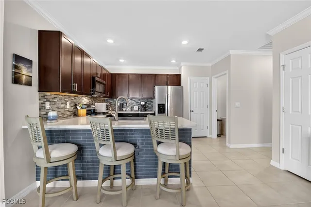 a kitchen with a dining table chairs refrigerator and cabinets