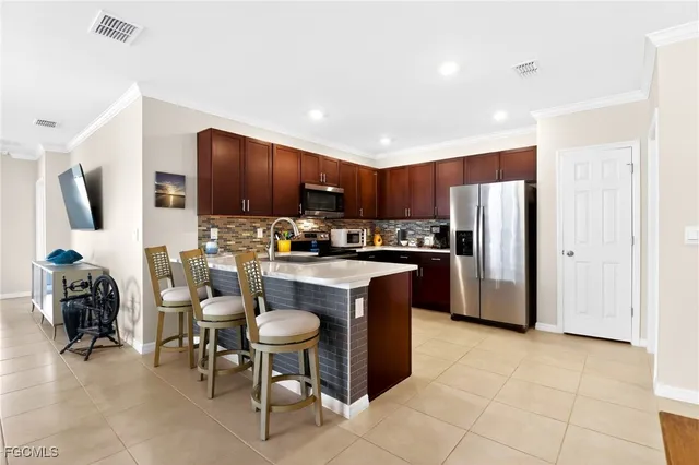 a kitchen with stainless steel appliances granite countertop a refrigerator and a stove top oven