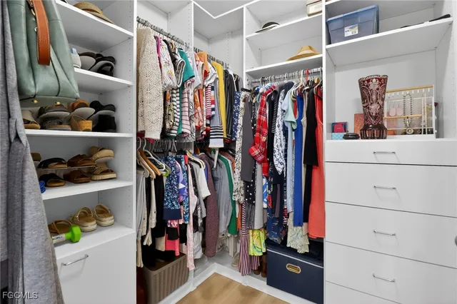 a view of walk in closet with clothes and shoes