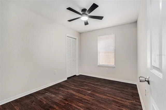 a view of empty room with wooden floor