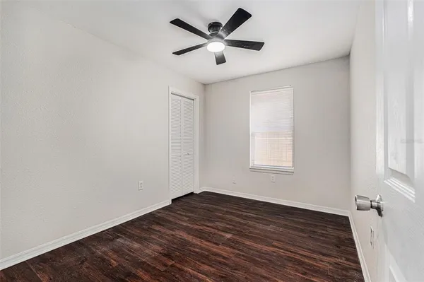 a view of empty room with wooden floor