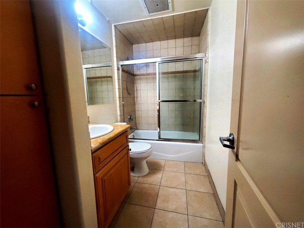 a bathroom with a granite countertop shower and a sink