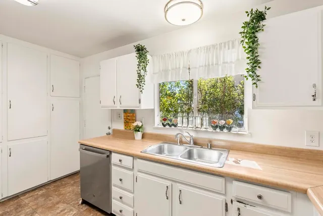 a kitchen with a sink a window and cabinets