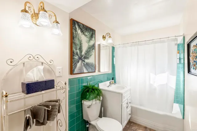 a white toilet sitting next to a bathroom sink and tub