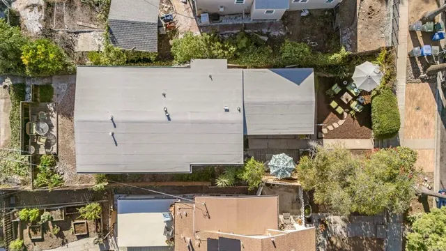 aerial view of a house with a yard and large trees