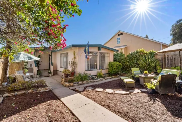 a view of a house with backyard and sitting area