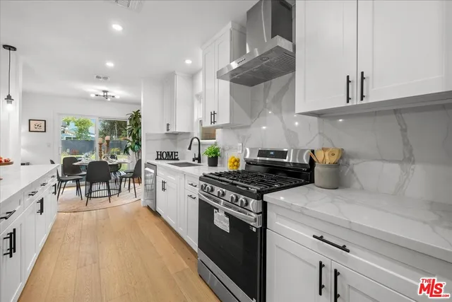 a kitchen with stainless steel appliances granite countertop a stove a sink and a refrigerator
