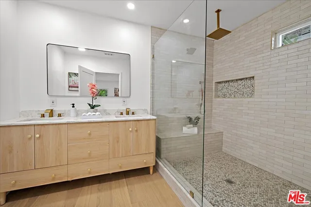 a bathroom with a double vanity sink mirror and shower