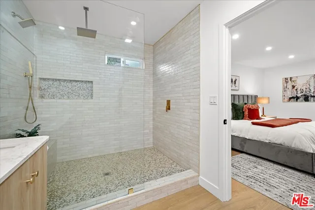 a bathroom with a granite countertop sink a mirror and shower