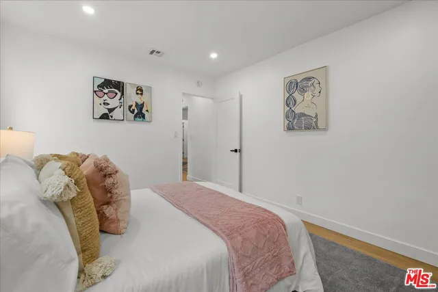 a bedroom with a bed and a wall painting