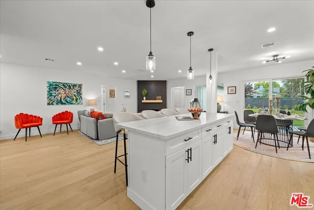a large room with kitchen island a sink a table and chairs
