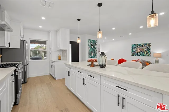 a kitchen with white cabinets and stainless steel appliances
