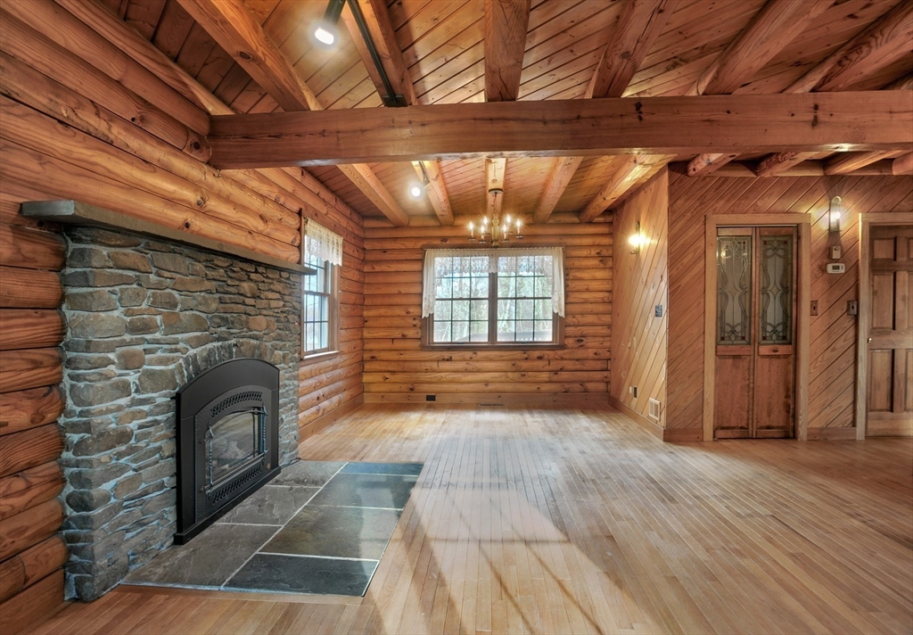 134 Crescent Street Hanson, MA 02341 - Photo 18 of 31 a view of empty room with wooden floor and fireplace