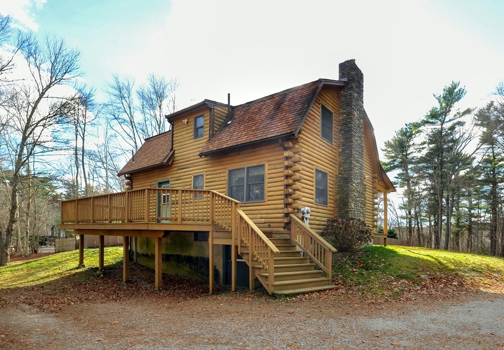134 Crescent Street Hanson, MA 02341 - Photo 6 of 31 a small house with a wooden bench and floor to ceiling window