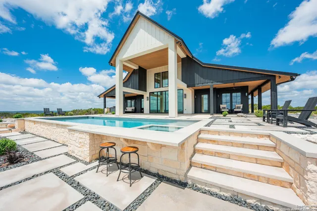 a view of a house with swimming pool and sitting area