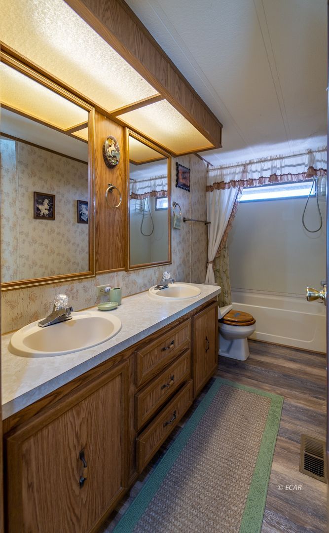 659 Spring Valley Lane Spring Creek, NV 89815 - Photo 12 of 25 a bathroom with a double vanity sink and a mirror