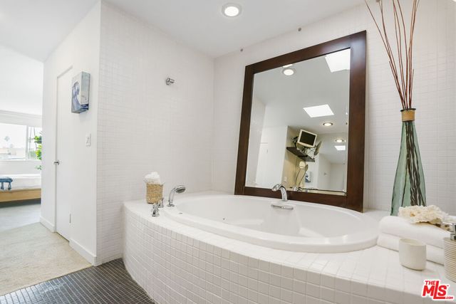 a white bath tub sitting next to a bathroom sink