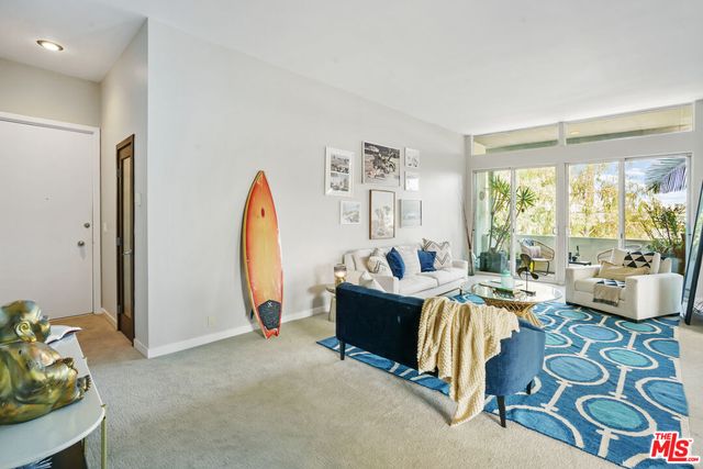 a living room with furniture a bed and a large window