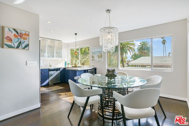 a dining room with furniture a chandelier and wooden floor