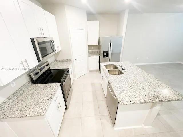 a en suite bathroom with a granite countertop sink and a mirror