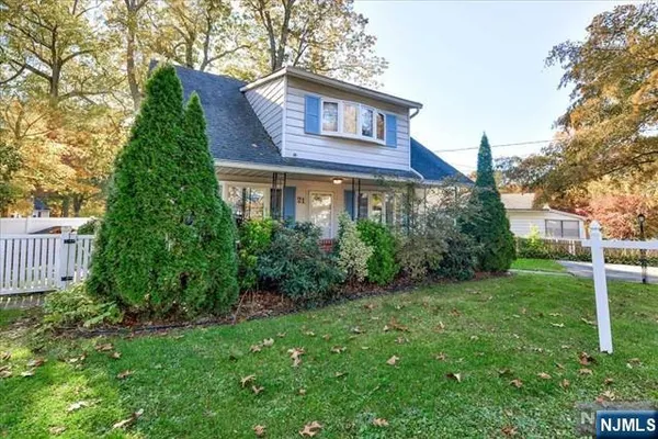 a view of a brick house next to a yard with plants and trees