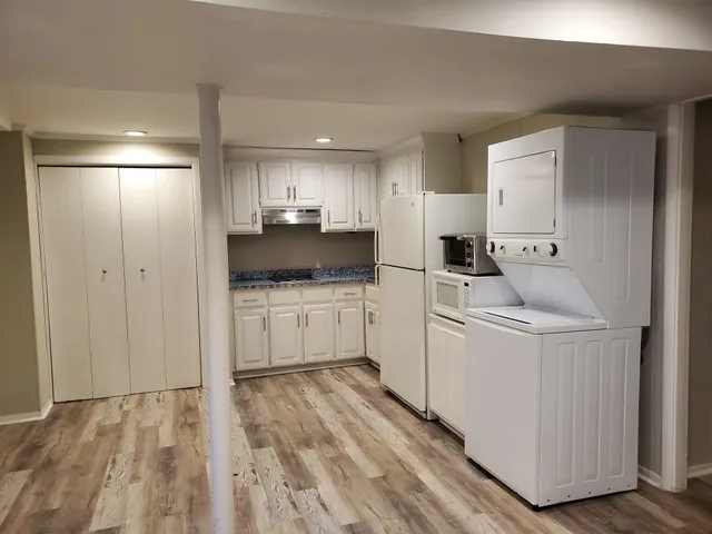 a kitchen with white cabinets and white appliances