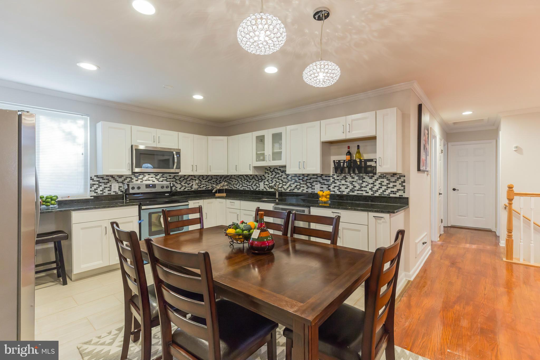 8303 Allentown Road Fort Washington, MD 20744 - Photo 7 of 30 a kitchen with a dining table chairs and refrigerator