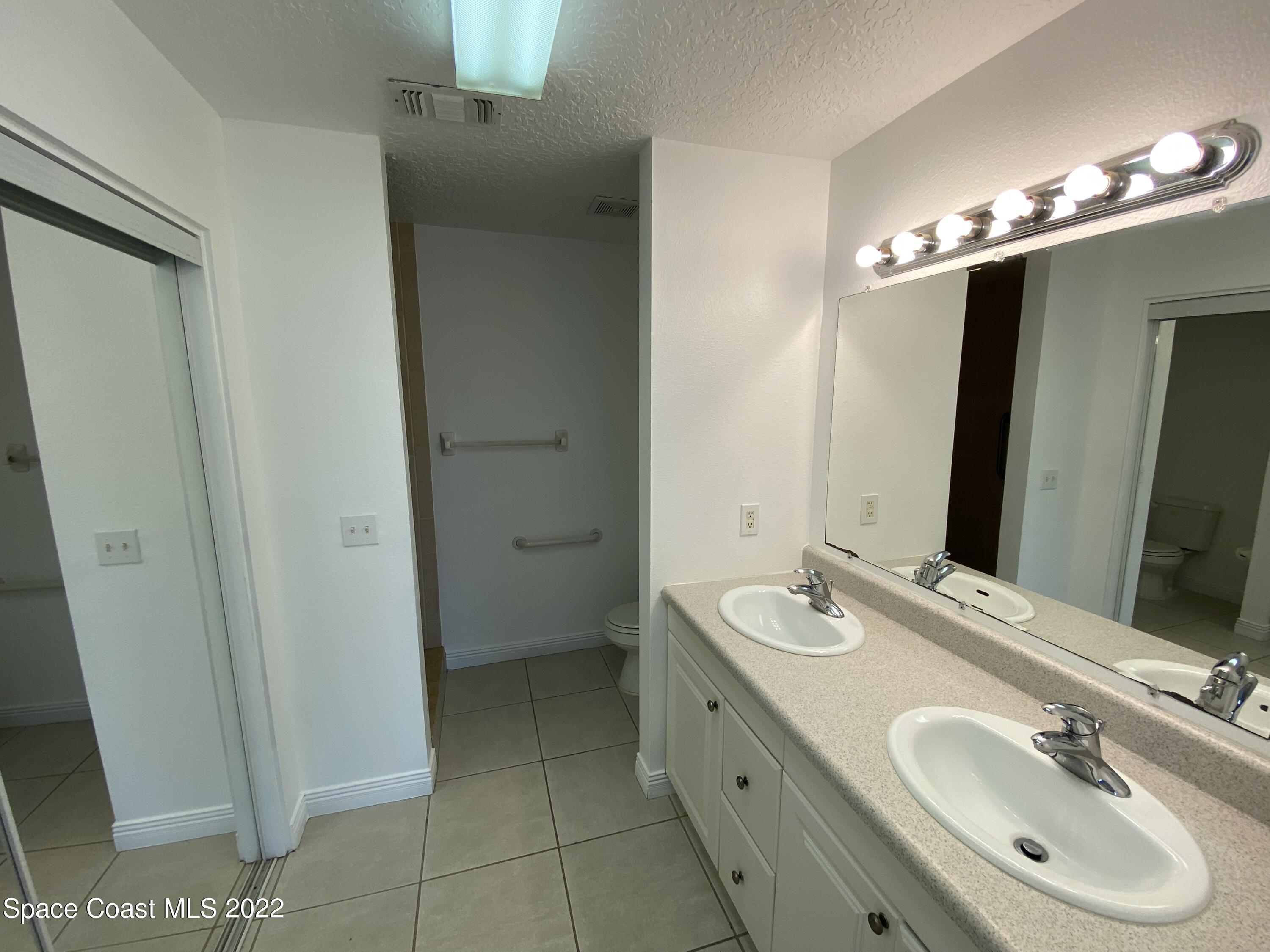 4120 Duke Street Melbourne, FL 32901 - Photo 31 of 49 a bathroom with a double vanity sink mirror and shower